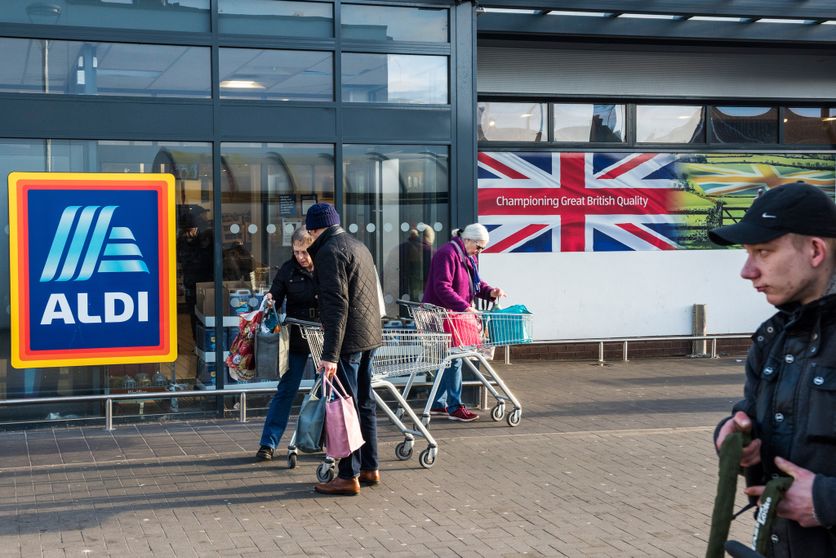 Shoppers outside a branch of the German supermarket chain Aldi L’impact du Brexit sur la pauvreté au Royaume-Uni