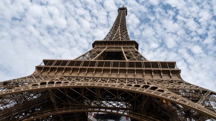 d5913f84-92ad-446f-b2aa-c2ab05fa0749 Un homme escalade la tour Eiffel et accroche un drapeau américain