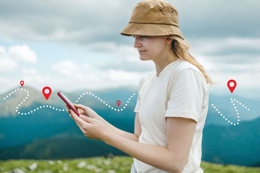 Success tourist woman searching right direction on smartphone on top of mountain with nature background. Mountain progression path. Les applications mobiles transforment la randonnée
