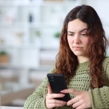 Suspicious young woman checking phone at home ChatGPT: Une Version Pour Adolescents