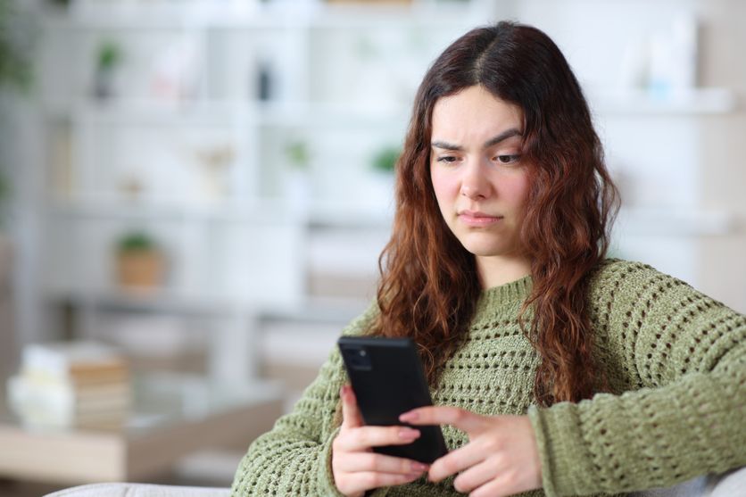 Suspicious young woman checking phone at home ChatGPT: Une Version Pour Adolescents