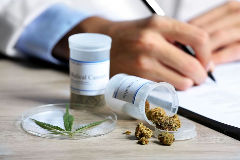 Doctor writing on prescription blank and bottle with medical can Les défis de l’autorisation du cannabis médical en France
