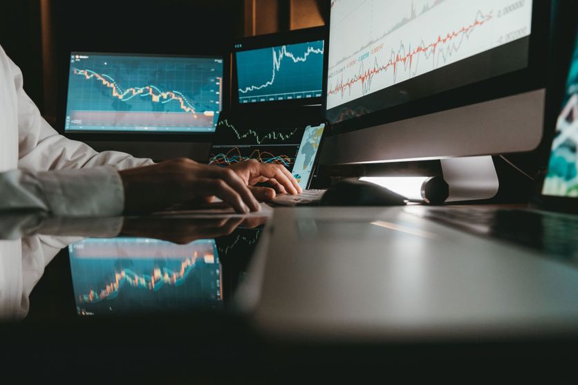Close-up of male trader typing on computer keyboard while trading on stock market in night office Les fonds spéculatifs et leur influence croissante sur le marché de la dette souveraine