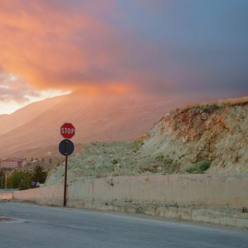 Serene sunset over mountain landscape with a stop sign and clouds Critique de « Une maison au Levant » par Carole Dagher
